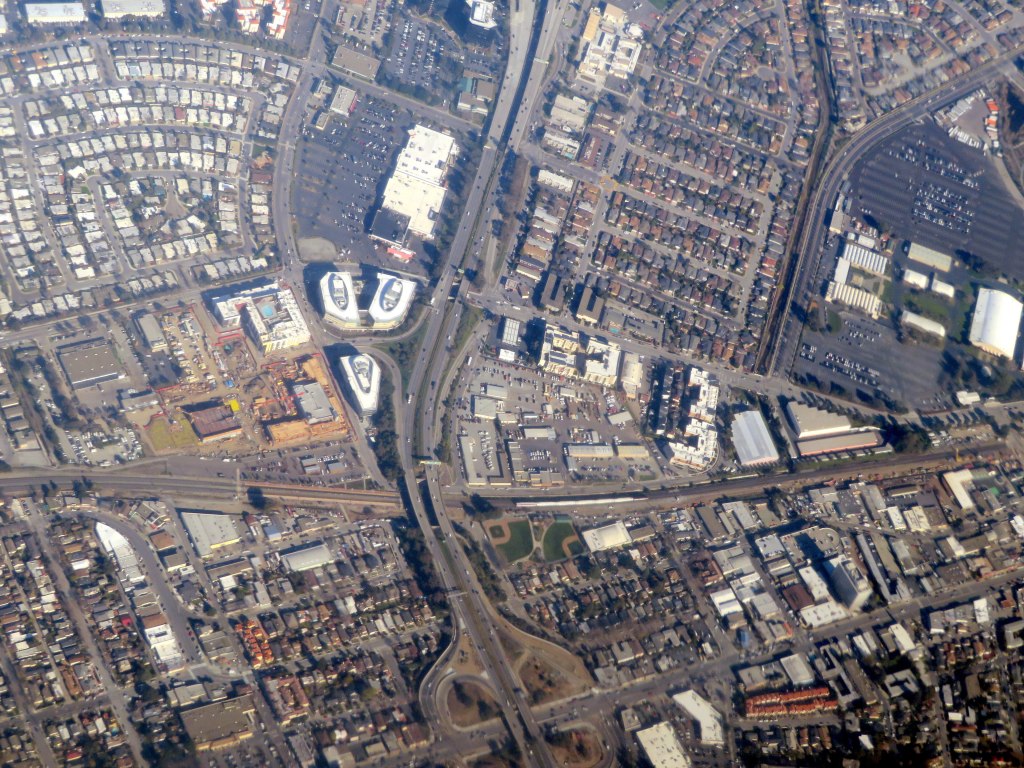 Aerial photo of a San Mateo neighborhood with a freeway interchange, office buildings and a rail line