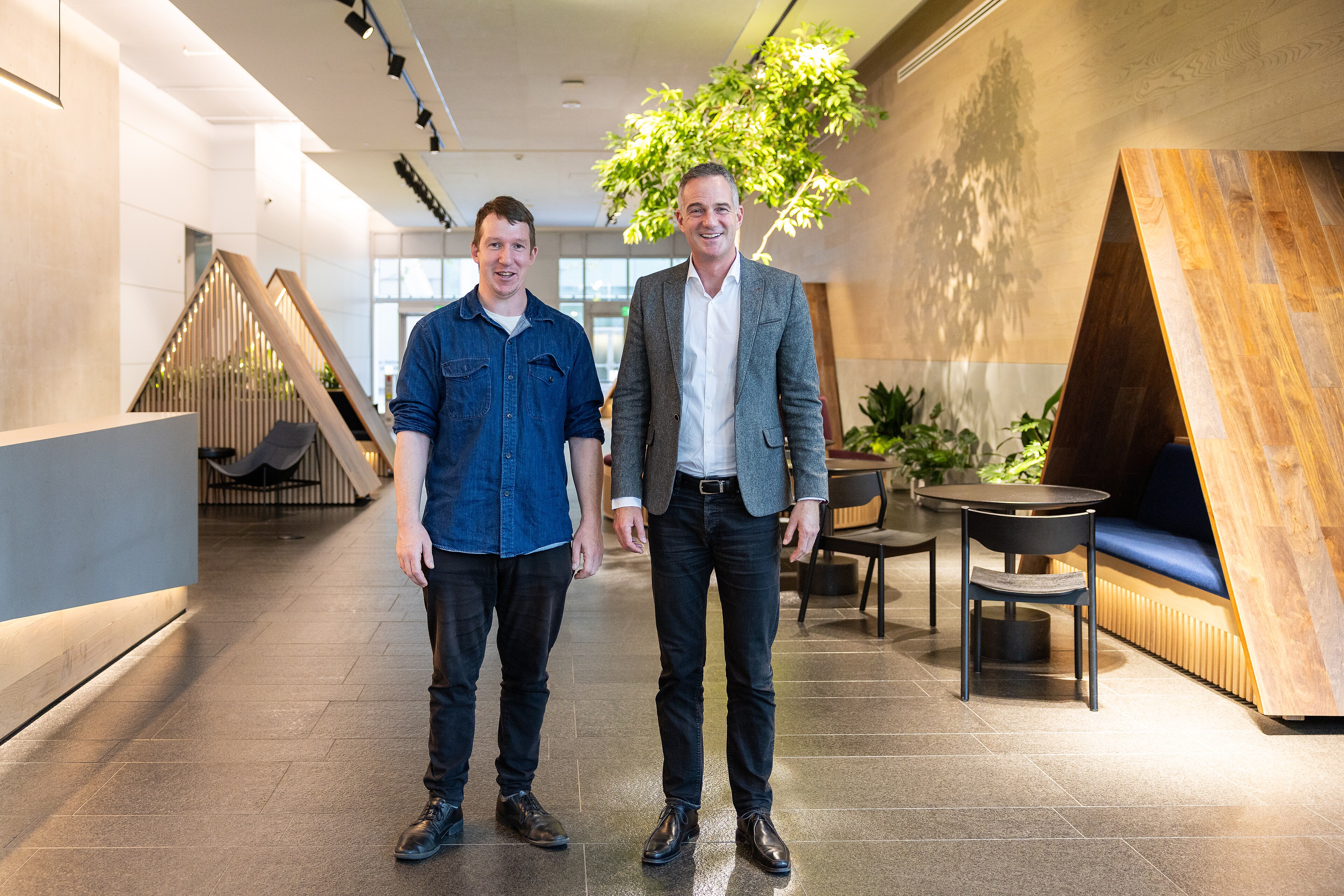 A visitor in a suit talks with a host inside Anthropic's San Francisco offices