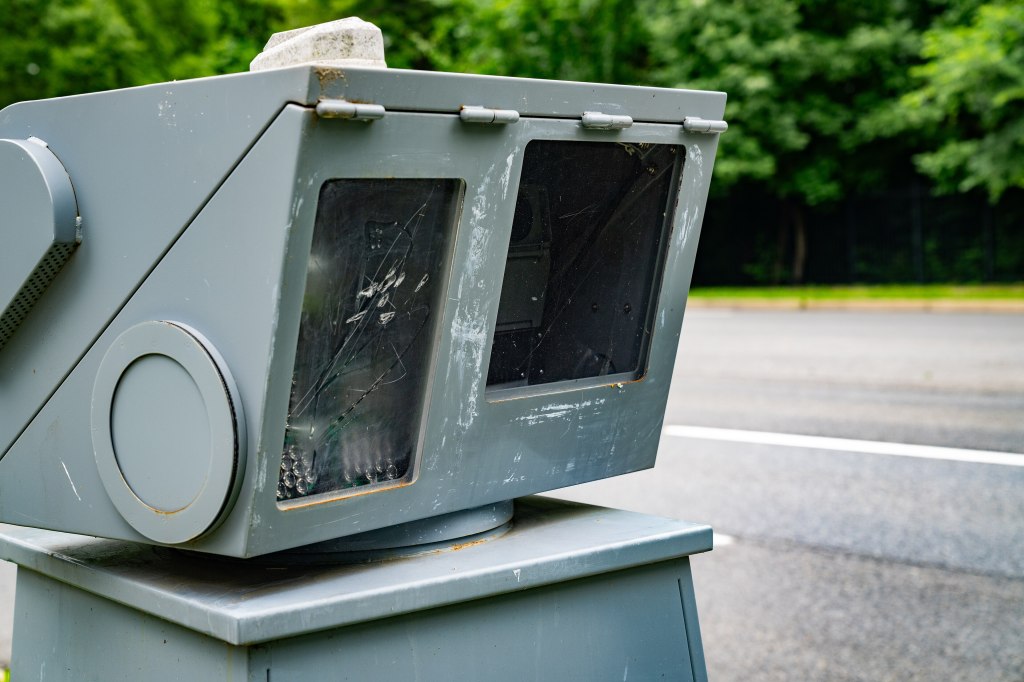 A pole-mounted automated speed enforcement camera beside a roadway