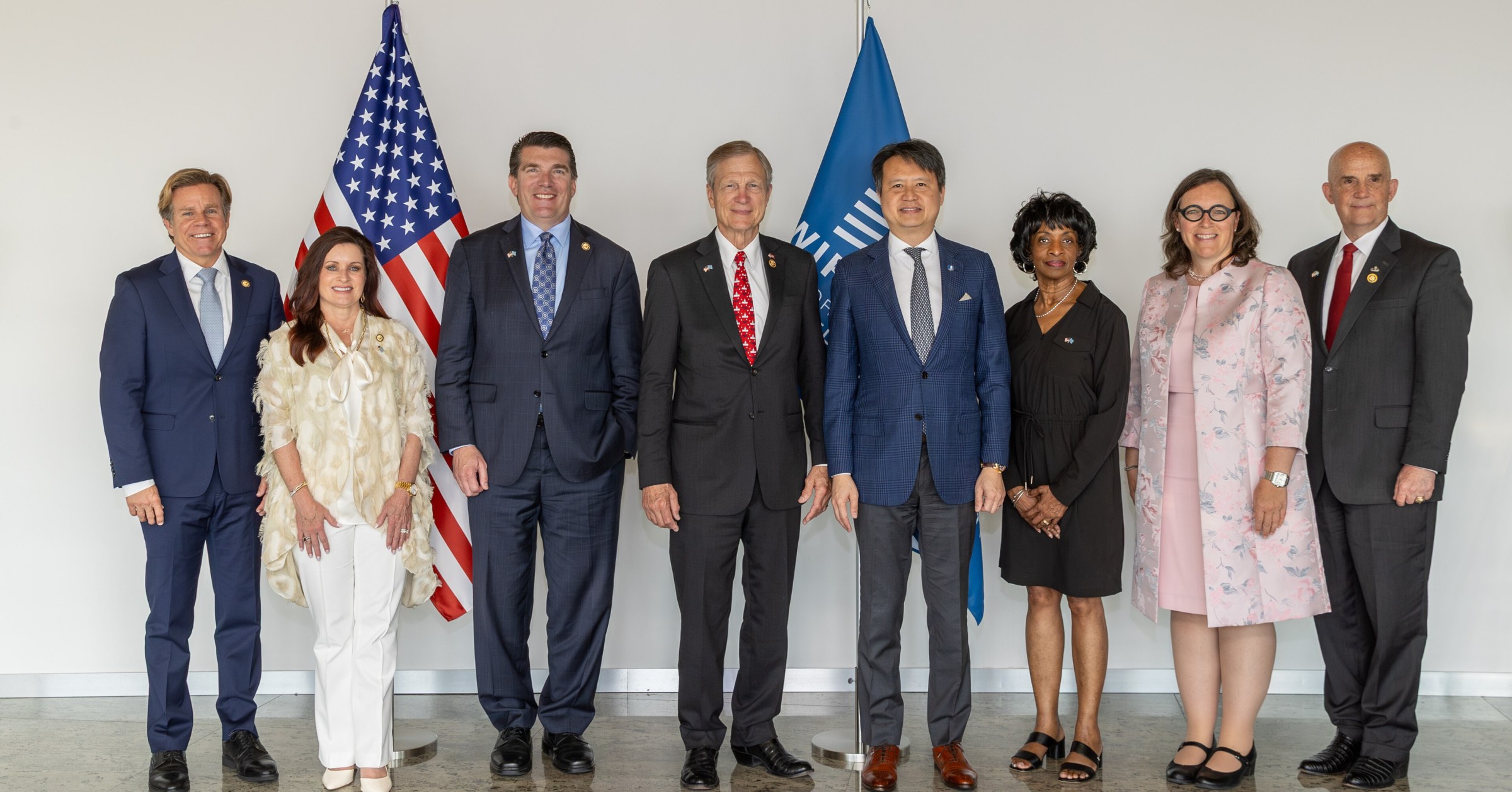 Eight people stand in a row in front of U.S. and WIPO flags, including Reps. Mike Haridopolos, Sheri Biggs, Jay Obernolte, Brian Babin and Valerie Foushee with WIPO Director General Daren Tang.