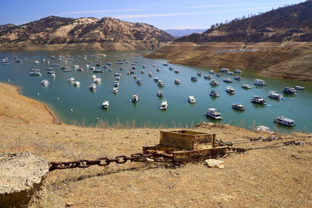 Houseboats on a shrunken Lake Oroville with exposed bare shoreline during the 2021 drought