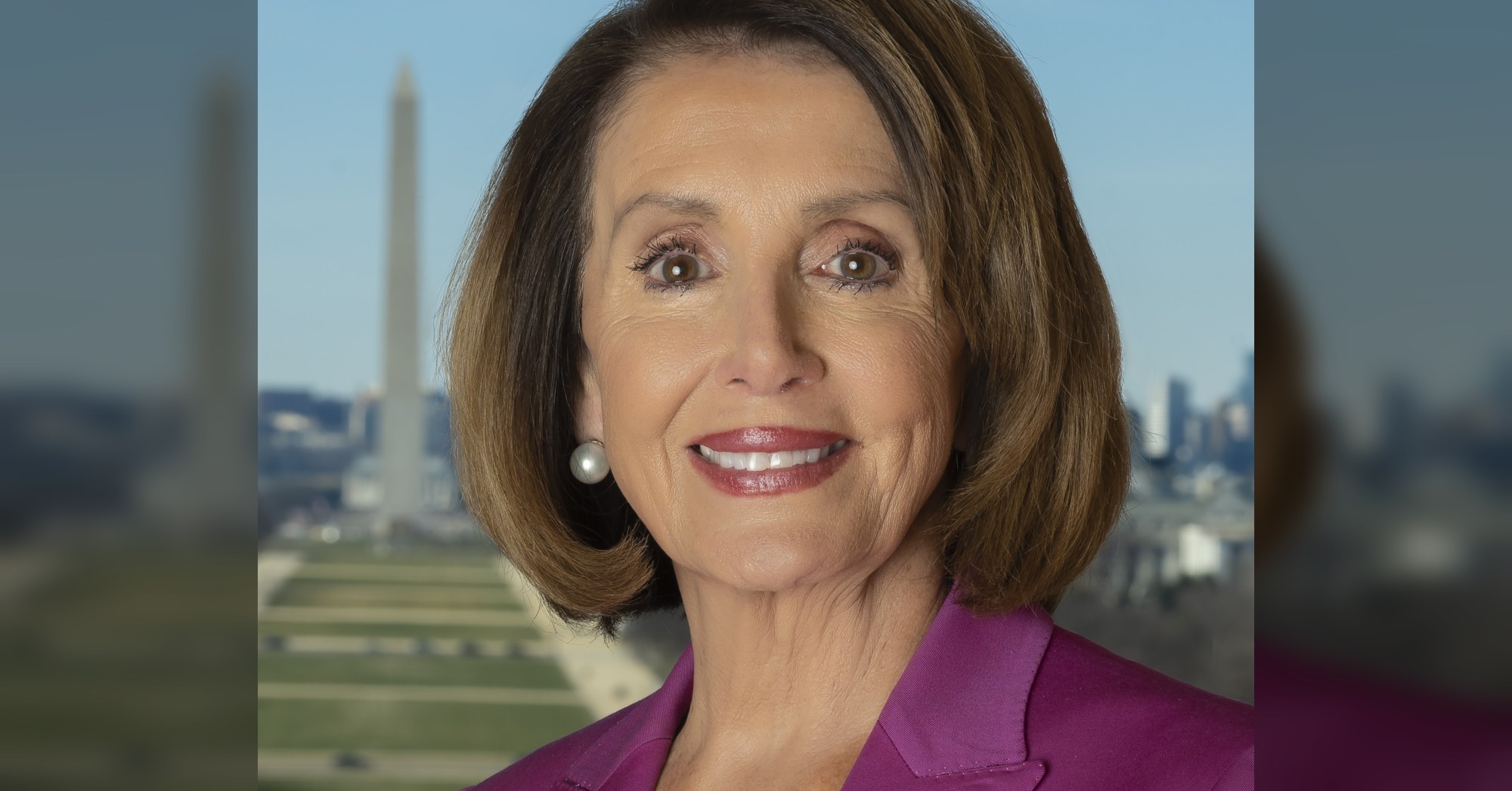 Official portrait of Nancy Pelosi smiling in front of an American flag.